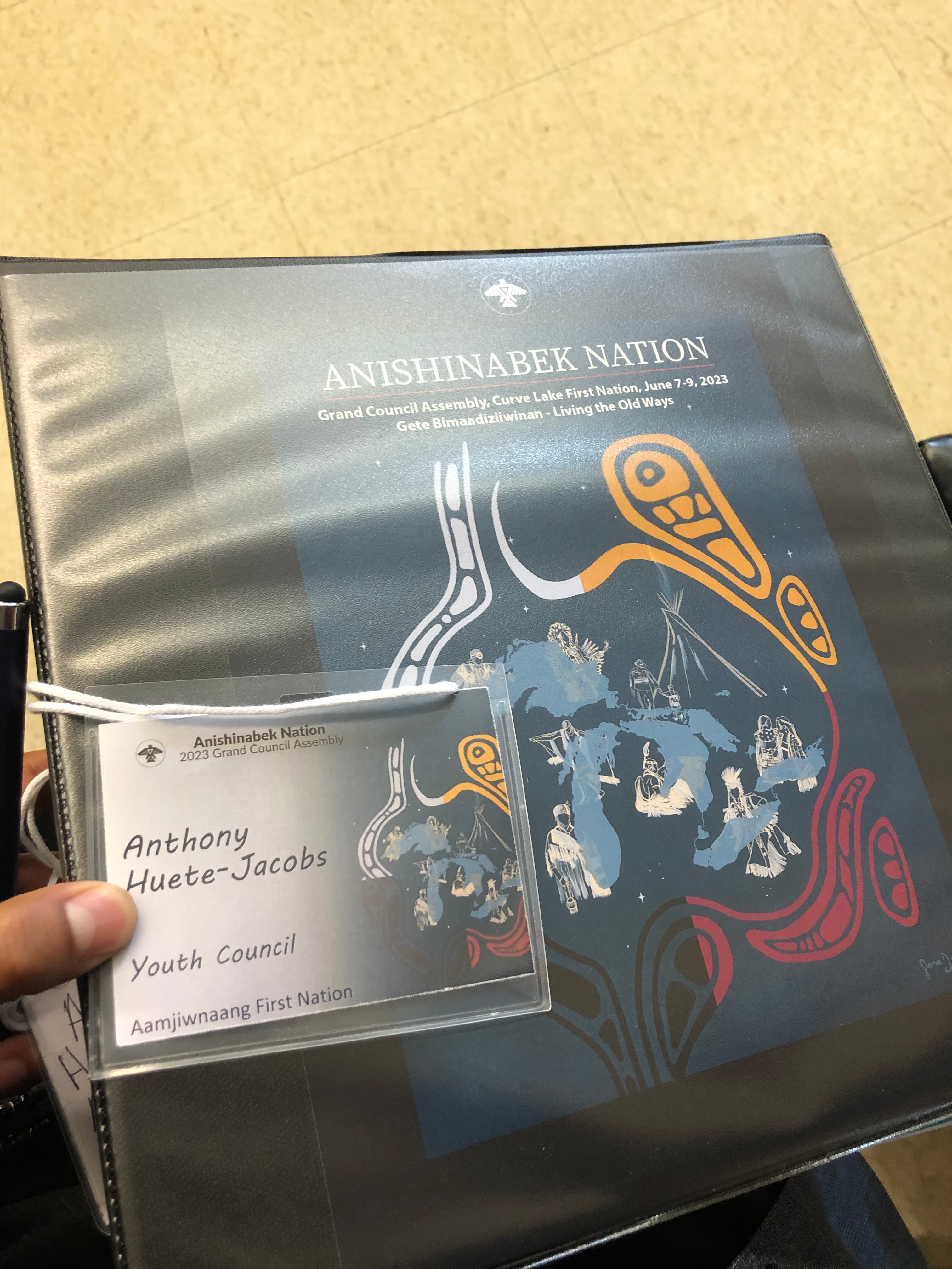Anthony Huete-Jacobs’s Aamjiwnaang Youth Council name badge and program from the 2023 Anishinabek Nation Grand Council Assembly